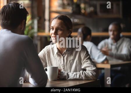 Millennial couple enjoy talking drinking coffee in cafe Stock Photo
