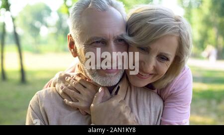 Happy old couple hugging, resting in park together, grandparents closeness Stock Photo