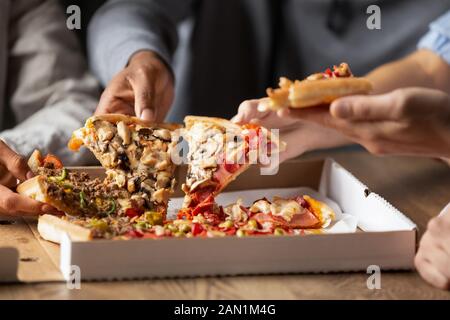 Close up of multiethnic friends share delicious pizza Stock Photo