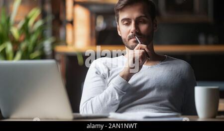 Pensive male thinking over problem solution working on laptop Stock Photo