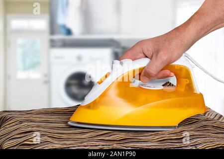 Man ironing clothes. The concept of the work division in a commonehold between man and woman in the modern family. Caring the home and helping househo Stock Photo