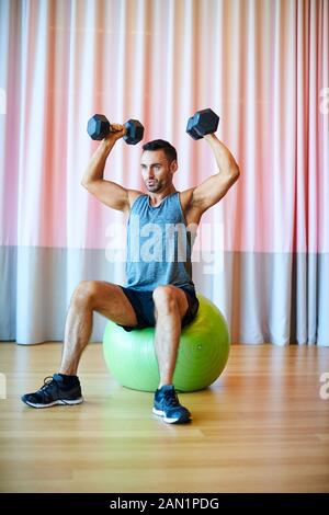 A man doing a shoulder press in the gym. Stock Photo