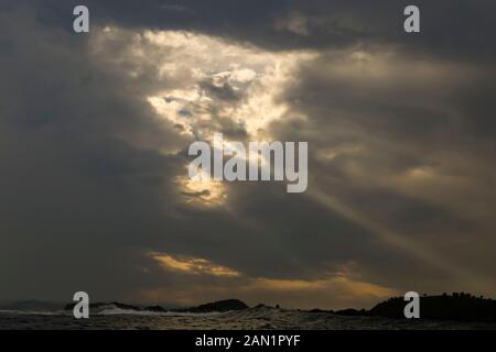 Sunlight shining through dark clouds Stock Photo