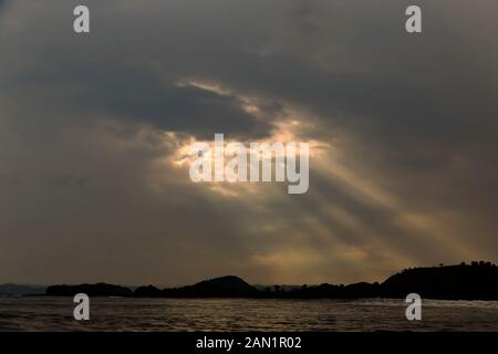 Sunlight shining through dark clouds Stock Photo