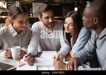Multiracial young people studying in coffeehouse together Stock Photo