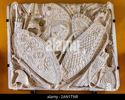 Instruments of war. A beautifully carved tropaion of weapons; one of the archeological finds on display in Zaquizami's Corridor in Casa de Pilatos Stock Photo