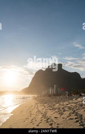 Rio de Janeiro, Brazil - January 7, 2020: Sunset from Sao Conrado Beach in Rio de Janeiro, with the tall seaside granite mountain Pedra da Gavea. Ther Stock Photo