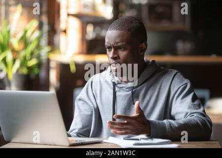 Angry black guy having laptop software problems Stock Photo