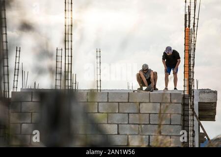 Low angle view of construction workers on roof. Stock Photo