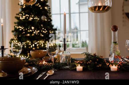 tall candle on a festively decorated dinner table at Christmas Stock Photo