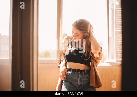 Young woman standing in balcony at home during summer Stock Photo