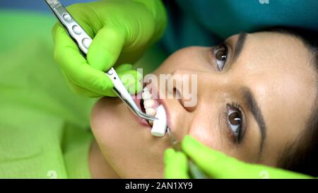 Stomatologist taking out cotton roll from female patient mouth, close up Stock Photo