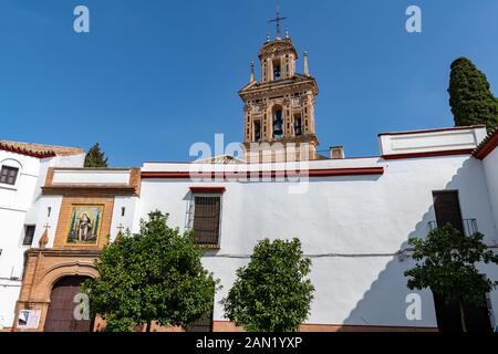 The belfry of the 15th century Monasterio de Santa Paula towers over the ornate façade of the convent on Calle Santa Paula, Seville. Stock Photo