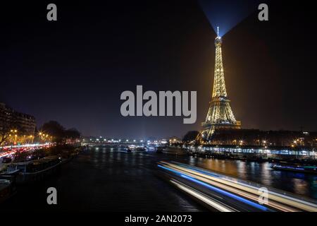 The lights of a riverboat illuminate the Seine River on New Year's Eve Stock Photo