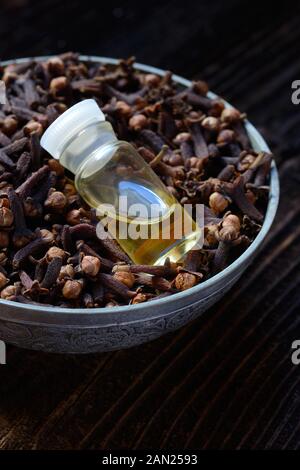 Cloves in a bowl and clove oil, clove oil, Germany Stock Photo