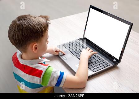 Boy use a laptop computer mockup. Isolated screen for app, game or web site design presentation. Concept of working and playing on a computer Stock Photo