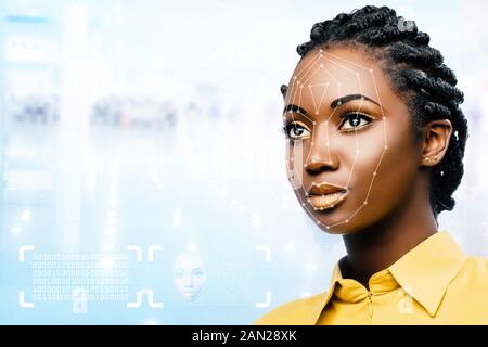 Close up portrait of attractive young african woman showing conceptual face recognition safety scan. Stock Photo