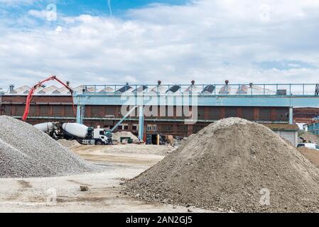 Trucks with cement or concrete and piles of sand and gravel in Västra Hamnen, Malmo, Sweden Stock Photo