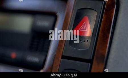 Car hazard warning flasher button on dashboard, emergency situations threat Stock Photo