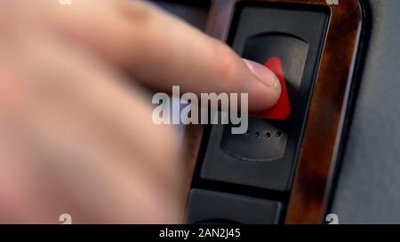 Male hand pressing emergency button in auto, stop by roadside, car accident Stock Photo