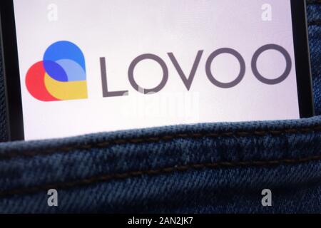 Lovoo logo displayed on smartphone hidden in jeans pocket Stock Photo