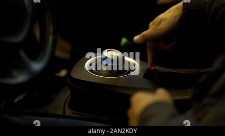 Car salesman showing electric vehicle control transmission, modern transport Stock Photo