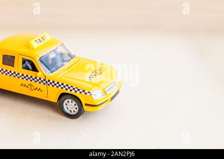 Simply design yellow vintage retro toy car Taxi Cab model on wooden background. Automobile and transportation symbol. City traffic delivery urban service idea concept. Copy space Stock Photo