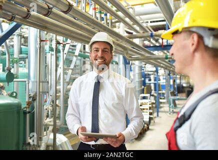 businessman and worker meeting in a factory - maintenance and repair of the industrial plant Stock Photo