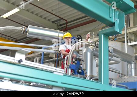 portrait of successful smiling workers/ engineers on site in an industrial factory with helmet Stock Photo