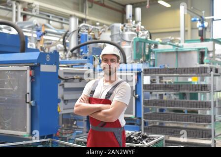 portrait of successful smiling workers/ engineers on site in an industrial factory with helmet Stock Photo