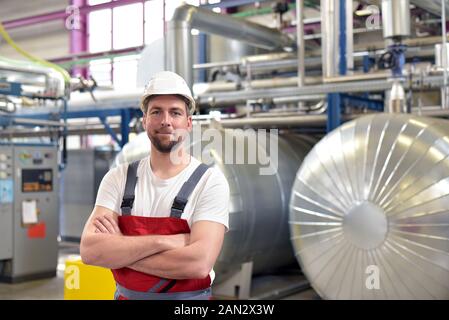 portrait of successful smiling workers/ engineers on site in an industrial factory with helmet Stock Photo