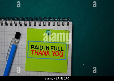 Paid in Full - Thank You write on a sticky note isolated on green background. Stock Photo