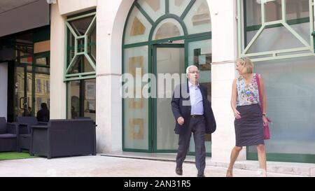 Happy adult couple leaving restaurant, satisfied with service, business lunch Stock Photo