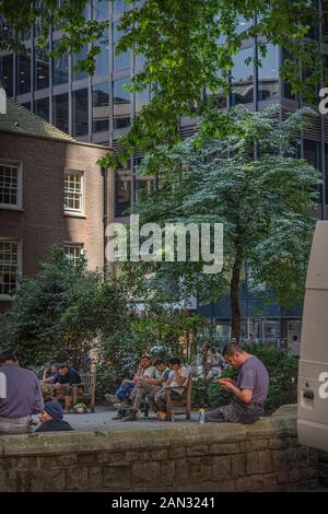 Construction workers on a lunch break in St Helen's churchyard, in the city of London Stock Photo