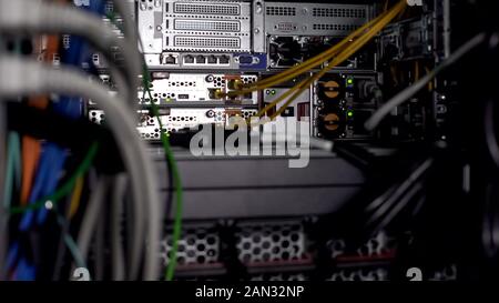 Computer cables and communications, server room with networking hardware closeup Stock Photo