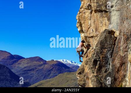 Female rock climber on steep cliff at Lordat, on sunny winter day above Ariege Valley, French Pyrenees, France Stock Photo