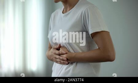 Woman with stomach pain touching tummy, suffering from gastritis, pancreatitis Stock Photo