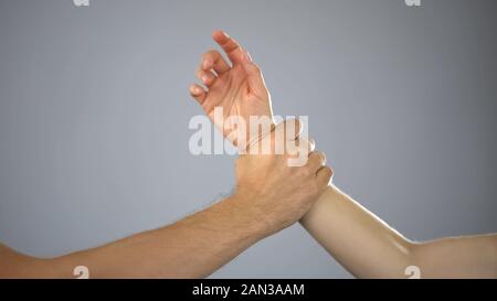 Male hand stopping woman who is about to hit, violence against man, home abuse Stock Photo
