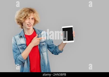 Young adult man pointing with finger on tablet computer Stock Photo