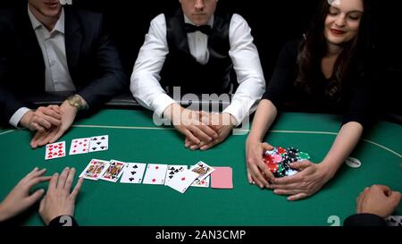 Casino players showing hands and woman winning game, property division concept Stock Photo