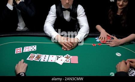 Woman winning all chips in poker game, players feel devastated, risky gambling Stock Photo