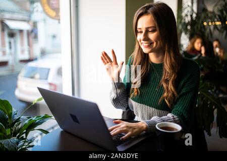 Young woman making video call in cafe Stock Photo