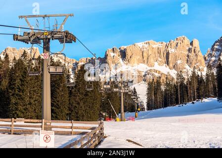 Empty chair lift in the Dolomites on a sunny winter day Stock Photo
