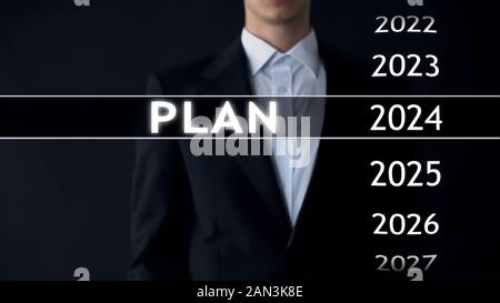 Plan for 2024, businessman chooses file on virtual screen, startup strategy Stock Photo
