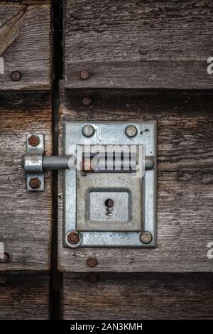 Ancient closed sliding bolt lock on a wooden door Stock Photo