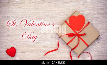 St Valentines Day phrase appearing on wooden background with craft gift box Stock Photo