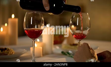 Waiter hand pouring wine in glass, traditional alcoholic beverage for dinner Stock Photo