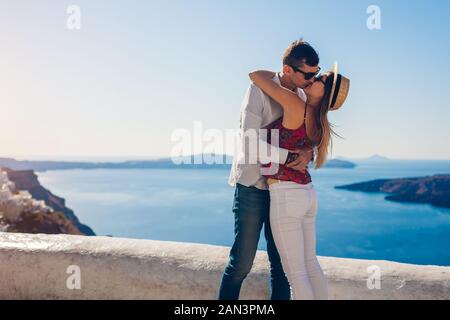 Valentines day. Couple in love kissing during honeymoon in Santorini island, Greece. People walking in Thera. Stock Photo