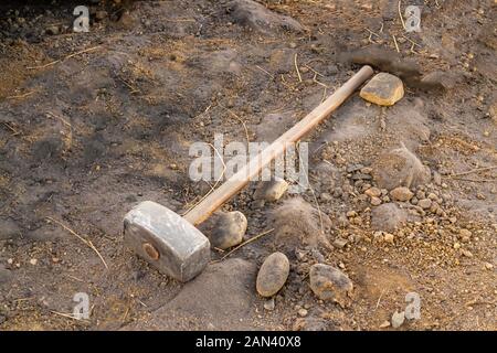 Dirty sledgehammer on soil and sand Stock Photo