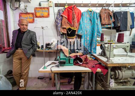 March 5, 2019: An elderly tailor man in a using a sewing machine. Yazd, Iran Stock Photo